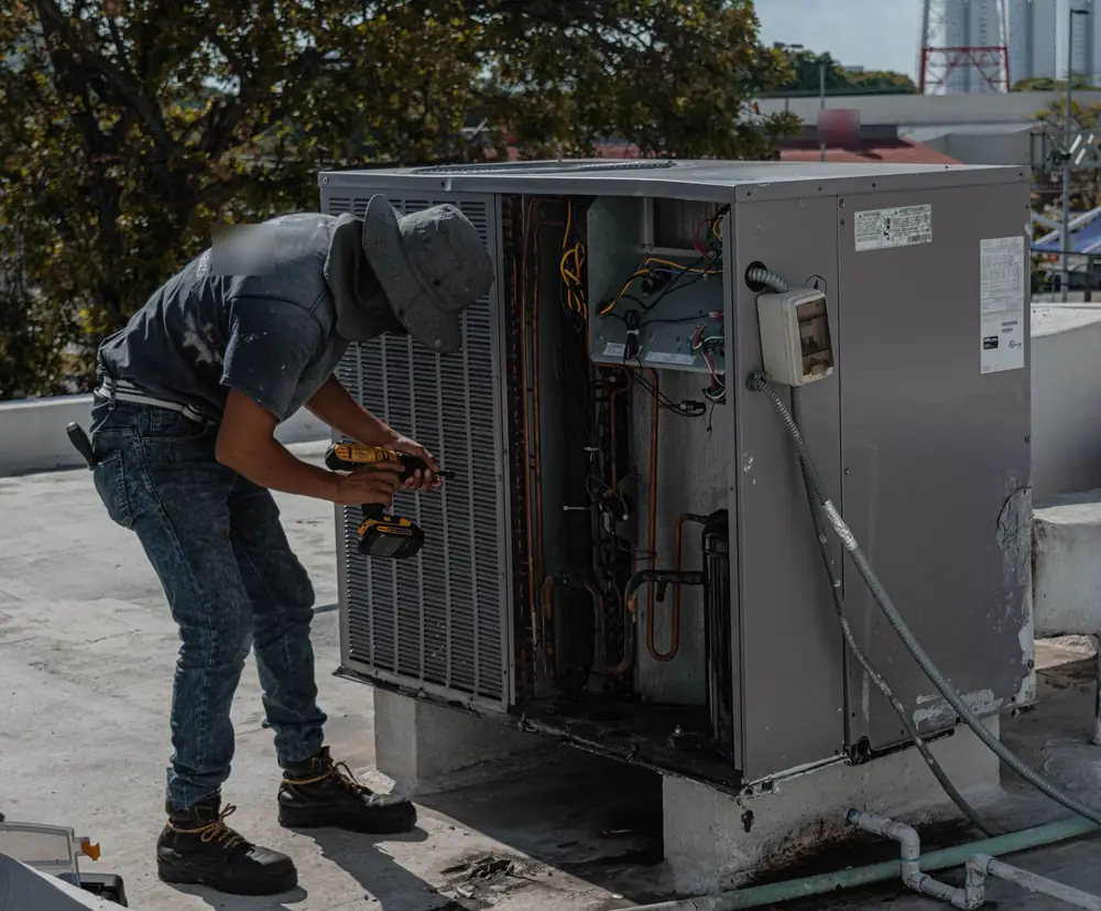 Technician working on a rooftop air conditioner