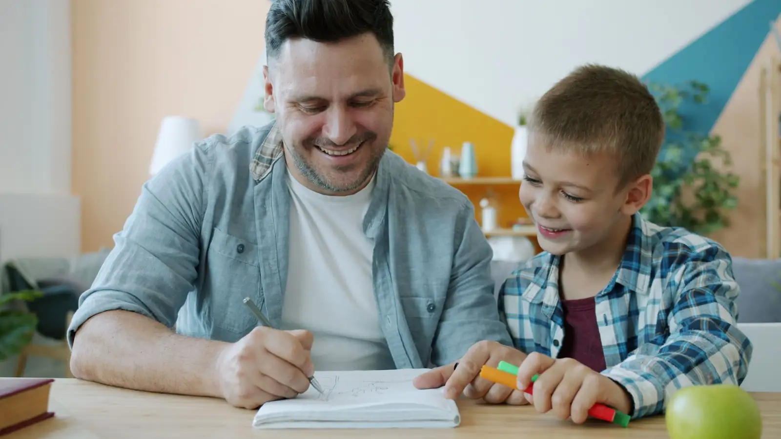 Father and son drawing together at home
