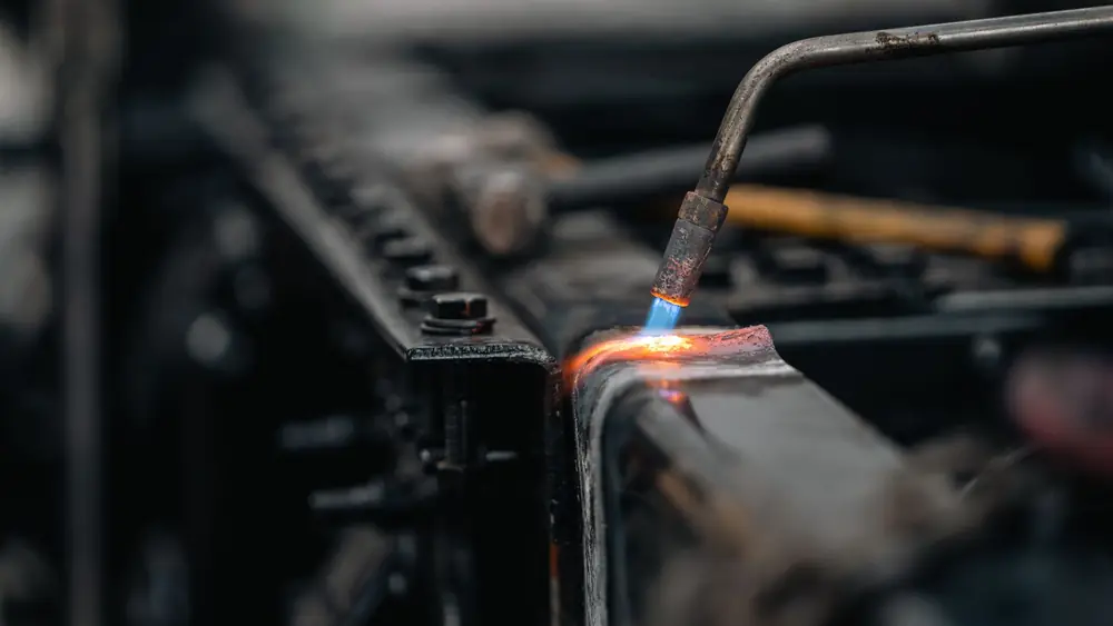 Technician brazing a metal heating component